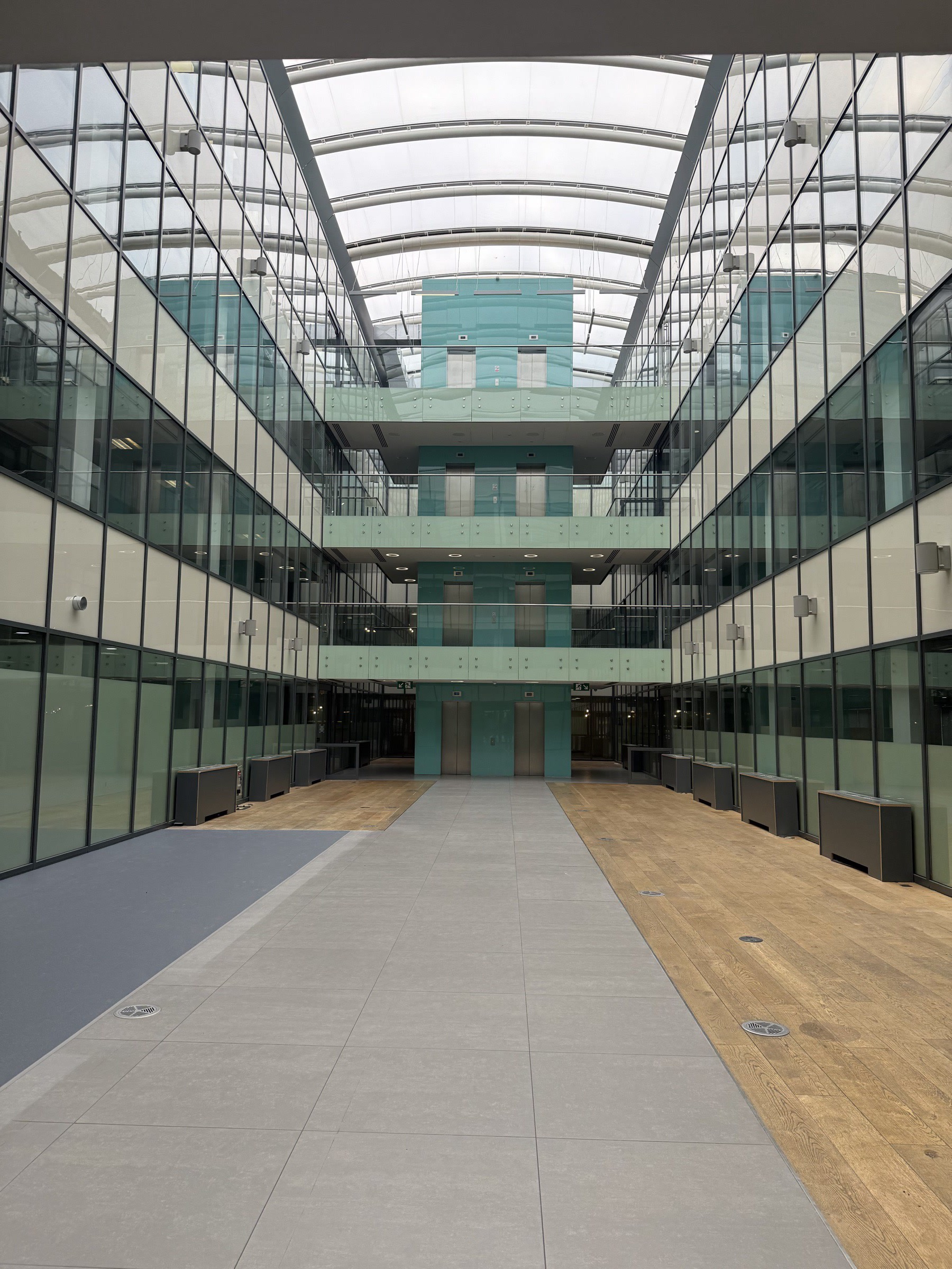 Pre-strip — atrium upper deck with the previous tenant fit-out